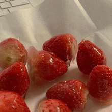 a bunch of strawberries are sitting on a white surface