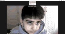 a screen shot of a zoom meeting with a boy in the foreground