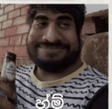 a man with a beard is holding a bottle of beer in his hand .