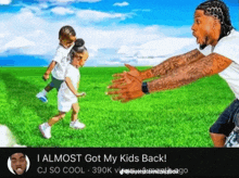 a man with a tattoo on his arm is playing with two children in a grassy field