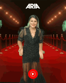 a woman in a black dress is on a red carpet with youtube music in the corner