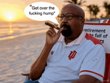 a man smoking a cigar on the beach with a speech bubble that says " get over the fucking hump "