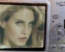 a woman 's face is on the screen of a camera .