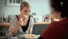 a woman is sitting at a table with a plate of food in front of her and a sign that says ' salz '