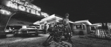 a black and white photo of a blue swallow motel at night