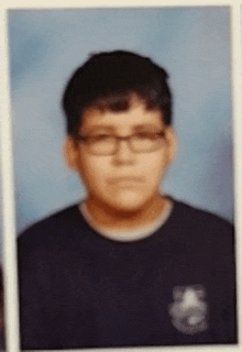 a young boy wearing glasses and a black shirt poses for a picture .