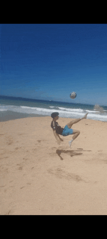 a person is doing a trick on a beach with a soccer ball