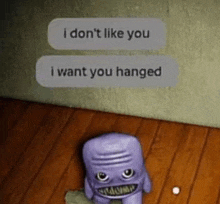 a purple stuffed animal is sitting on a wooden floor next to a wall and a text message .