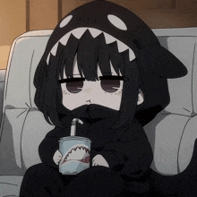 a girl in a shark costume drinking from a cup