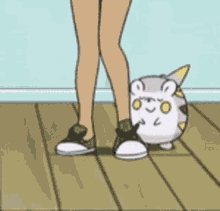 a cartoon character is standing next to a small white hamster on a wooden floor .