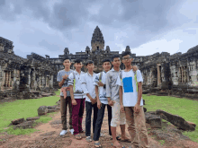 a group of young men pose for a picture in front of a building