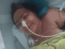 a woman is laying in a hospital bed with a tube in her mouth