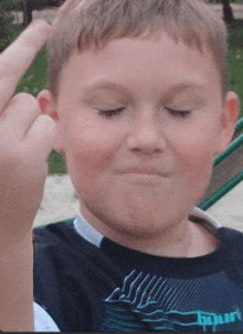 a young boy is giving the middle finger .