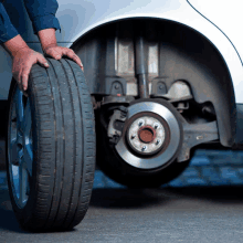 a close up of a person changing a tire on a car