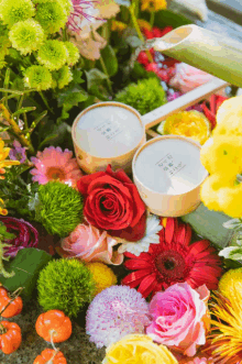 a bunch of flowers including roses and daisies are surrounded by two bowls that say ' aoi ' on them