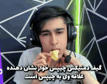 a young man wearing headphones is eating a piece of cheese