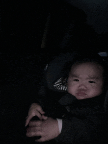 a baby in a car seat with the letter g on the side