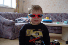 a young boy wearing sunglasses and a shirt with the letter b on it