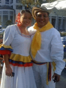 a man and a woman are posing for a picture and the woman has a yellow scarf around her neck