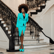 a woman in a bright blue suit is standing on stairs