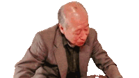 an elderly man in a suit is sitting down with his eyes closed