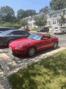 a red sports car is parked on the side of a road