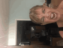 a woman is making a funny face in a kitchen