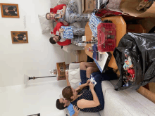 a man and woman sitting on a couch holding gifts with a box that says ' a ' on it in the background