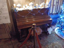 a piano is decorated with snowflakes and candles in a room