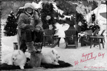 a black and white photo of a man sitting on a stump with two dogs and the words happy st nicholas day