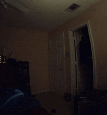 a dark room with a door open and a ceiling fan