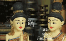 two wooden statues of a woman and a boy are standing next to each other in a room .