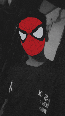 a person wearing a spider man mask and a black shirt that says jc on it