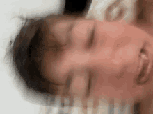 a blurry image of a person 's face with their eyes closed