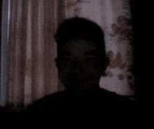 a shadow of a person 's face is visible in the dark