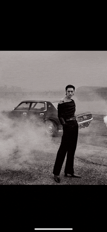 a black and white photo of a man standing next to a car .