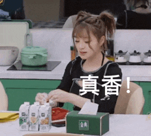 a woman sitting at a table with a box of tissues in front of her