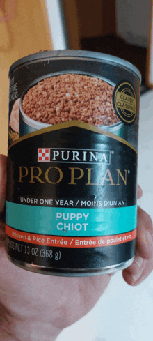 a person holds a can of purina pro plan puppy chiot