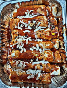 a close up of enchiladas in a tin foil pan