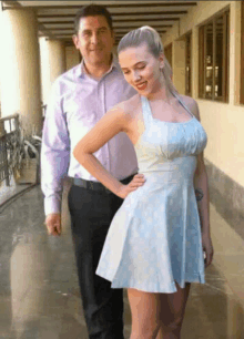 a man stands next to a woman in a blue dress