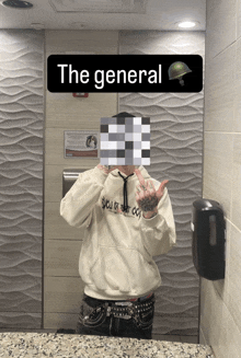 a person taking a picture in a bathroom with a sign that says the general above them