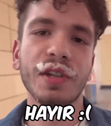 a close up of a man 's face with hayir written in white letters