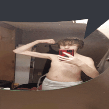 a shirtless man taking a picture of himself in a mirror