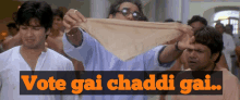 a man holding a piece of cloth with the words vote gai chandi gai written above him