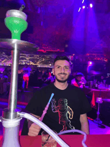 a man smoking a hookah in a club with purple lights