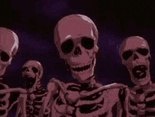 a group of skeletons are standing next to each other and looking at the camera .