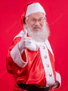 a man dressed as santa claus is giving a thumbs up sign