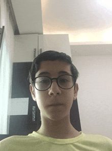 a young boy wearing glasses looks at the camera