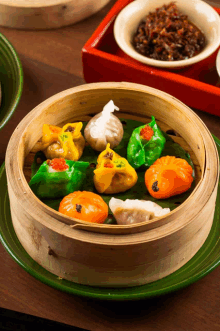 a bunch of different colored dumplings in a steamer