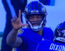 a man wearing a ravens helmet is giving a peace sign